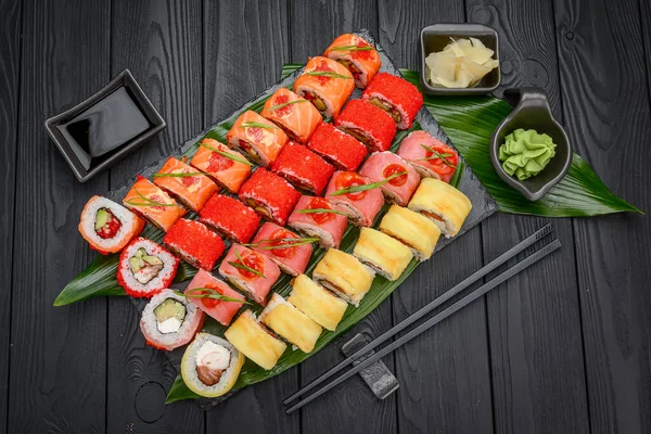 Sushi roll japanese food in restaurant. California Sushi roll set with salmon, vegetables, flying fish roe and caviar closeup. Japan restaurant menu