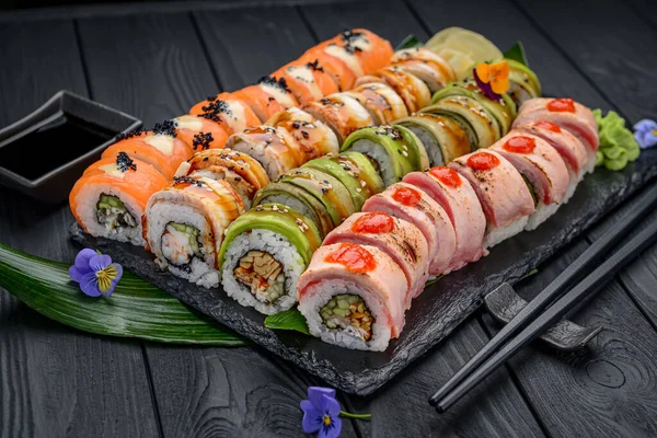 Sushi roll japanese food in restaurant. California Sushi roll set with salmon, vegetables, flying fish roe and caviar closeup. Japan restaurant menu