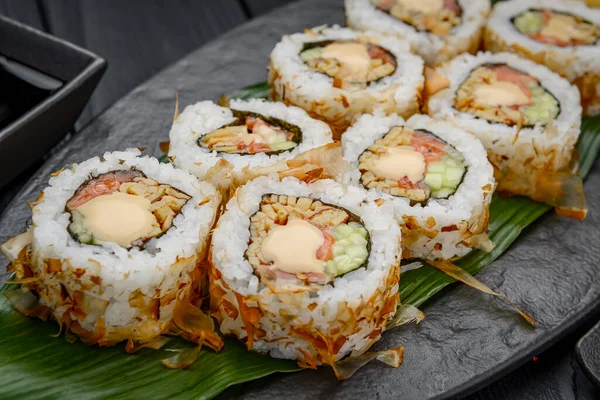 寿司卷与奶油奶酪 炸鲑鱼 金枪鱼片或干肉豆蔻 日本餐馆的特写镜头里 用筷子盛着新鲜的Katsuobushi卷 — 图库照片