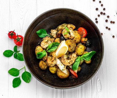 Taze deniz ürünleri, mürekkep balığı, karides, midye ve midye karışımı ve yanında salata ve kızarmış patates. Restoranda yemek servisi. Menü için fotoğraf