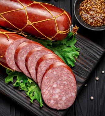 Esmer arka planda tütsülenmiş sosis, baharat, sarımsak ve fesleğen. Salam..