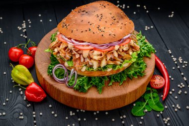 Izgara tavuk ve sebzeli sandviç. - Burger. Tavuk etli, soslu, domatesli, soğanlı büyük sandviç. Menü için fotoğraf