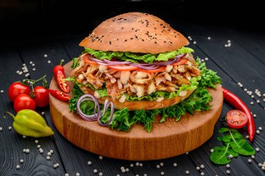 Izgara tavuk ve sebzeli sandviç. - Burger. Tavuk etli, soslu, domatesli, soğanlı büyük sandviç. Menü için fotoğraf