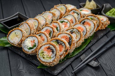 Tempura 'da bir dizi sıcak suşi. Lezzetli tempura ve somon, yılan balığı, salatalık, avokado, omlet ve karides karışımı. Japon Doğu mutfağı.