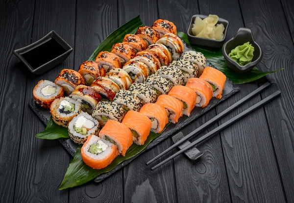 Sushi roll japanese food in restaurant. California Sushi roll set with salmon, vegetables, flying fish roe and caviar closeup. Japan restaurant menu