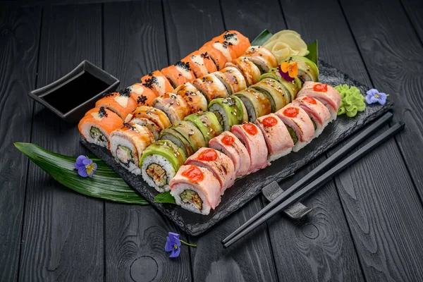 Sushi roll japanese food in restaurant. California Sushi roll set with salmon, vegetables, flying fish roe and caviar closeup. Japan restaurant menu