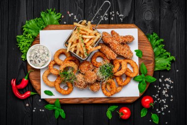 Mozarella toplarını, kalamar halkalarını, soğan halkalarını, patates kızartmalarını, tavuk nuggetlarını ve sosu çıkarın.