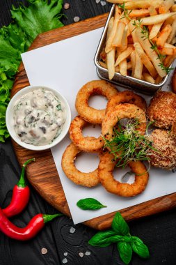 Mozarella toplarını, kalamar halkalarını, soğan halkalarını, patates kızartmalarını, tavuk nuggetlarını ve sosu çıkarın.