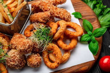 Mozarella toplarını, kalamar halkalarını, soğan halkalarını, patates kızartmalarını, tavuk nuggetlarını ve sosu çıkarın.