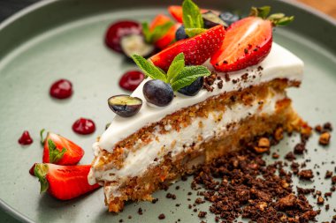 Krem peynirli havuçlu kek ve seramik tabakta böğürtlen.