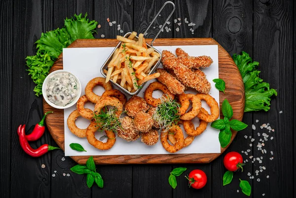 Mozarella toplarını, kalamar halkalarını, soğan halkalarını, patates kızartmalarını, tavuk nuggetlarını ve sosu çıkarın.