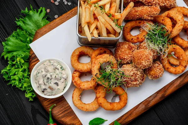 Mozarella toplarını, kalamar halkalarını, soğan halkalarını, patates kızartmalarını, tavuk nuggetlarını ve sosu çıkarın.