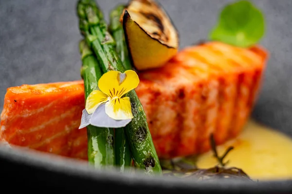 Grilled salmon steak with cheese sauce and asparagus