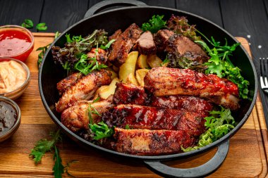 Farklı türde et, tavuk, dana eti, ızgara domuz eti. Patatesli tavada servis yap. BBQ eti