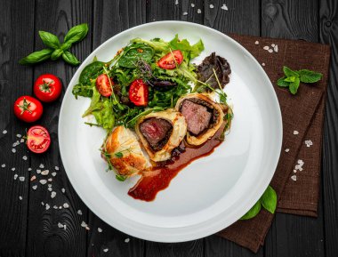 Wellington usulü sığır eti, klasik biftek, yeşil salatalı klasik tarif. Restoranda yemek servisi. Sağlıklı gıda konsepti. Menü için fotoğraf