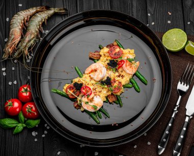 Karidesli omlet, havyar ve kuşkonmaz fasulyesi ve pastırmalı ızgara domates. Restoranda yemek servisi. Sağlıklı gıda konsepti