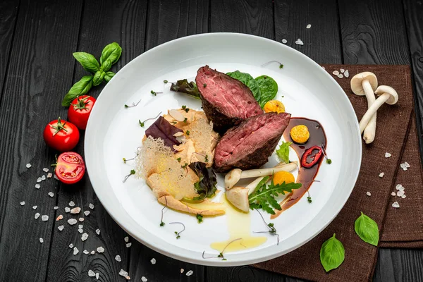 Salata ve humus ile dana madalyonu. Restoranda yemek servisi. Sağlıklı gıda konsepti. Menü için fotoğraf