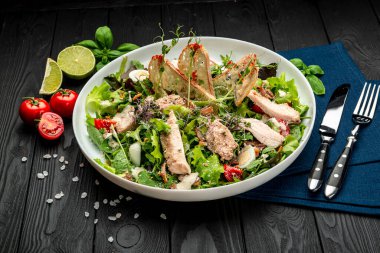 Siyah ahşap masada beyaz tabakta taze sezar salatası. Üst Manzara. Restoranda yemek servisi. Sağlıklı gıda konsepti. Menü için fotoğraf