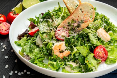 Karidesli taze sezar salatası. Restoranda yemek servisi. Sağlıklı gıda konsepti. Menü için fotoğraf