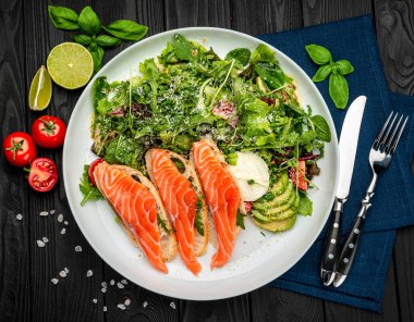 Taze salata ve ahşap arka planda krem peynirli kızarmış somon balığı. Sağlıklı gıda konsepti.