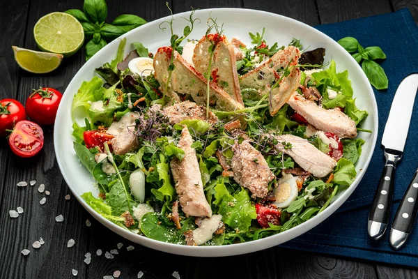 Siyah ahşap masada beyaz tabakta taze sezar salatası. Üst Manzara. Restoranda yemek servisi. Sağlıklı gıda konsepti. Menü için fotoğraf