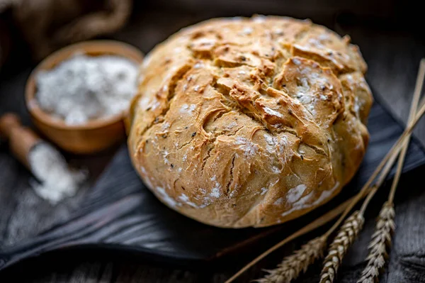 Tahta bir masada taze ev yapımı ekmek. Sağlıklı yiyecekler. Eski bir tarife göre fırında ekmek pişirmek..