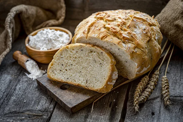 Tahta bir masada taze ev yapımı ekmek. Sağlıklı yiyecekler. Eski bir tarife göre fırında ekmek pişirmek..