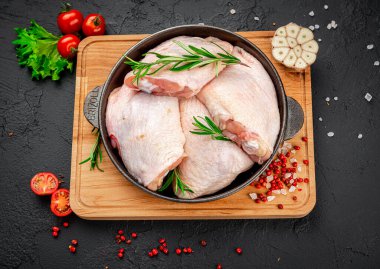 Siyah arka planda çiğ tavuk budu. Sağlıklı gıda konsepti.