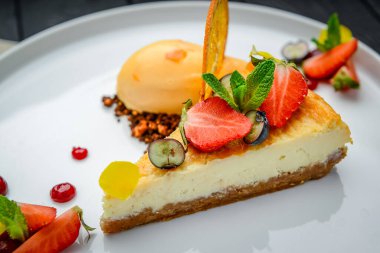 Böğürtlenli cheesecake ve tabakta şerbet. Restoranda yemek servisi. Sağlıklı yemek.
