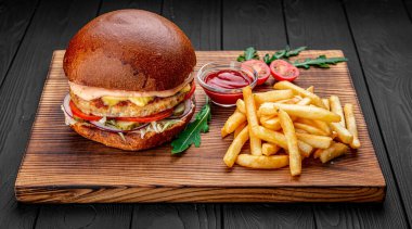 Tavuk burger bir restoranda servis edilir, koyu arka planda.