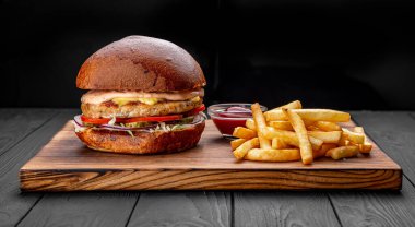 Tavuk burger bir restoranda servis edilir, koyu arka planda.