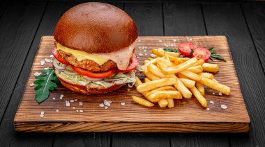 Taze lezzetli hamburger ve koyu arkaplanda patates kızartması