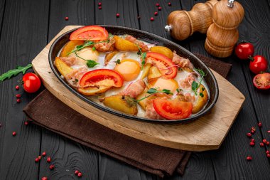 Siyah beton arka planda patates etli ve yumurtalı tava. Meksika yemeği konsepti. Tavada kızarmış patates.