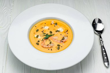 Sweet Potato Soup with Carrot, Pumpkin, Shrimps, Feta Cheese, Parsley. Healthy food. Photo for the menu.