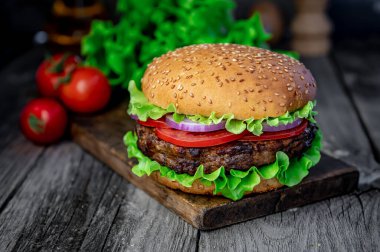 Tahta masada taze lezzetli bir burger. Restoranda nefis ızgara yemekler.