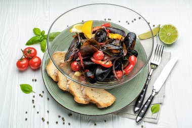 Çeşitli sebzeler, baharatlar ve kıtır ekmeklerle haşlanmış midye servis ediyorlar.