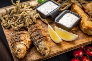 Tahtada farklı kızarmış balıklar var. Restoranda yemek servisi.