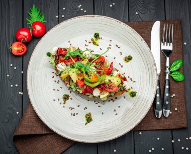 Güneşte kurutulmuş domatesler, krem peynir, avokado ve taze sebzeler. Sağlıklı ve sağlıklı yiyecekler. Restoranda yemek servisi. Menü için fotoğraf.