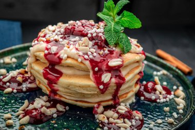 Yoğurtlu, fındıklı ve vişneli krep kulesi. Sağlıklı ve sağlıklı yiyecekler. Restoranda yemek servisi. Menü için fotoğraf.