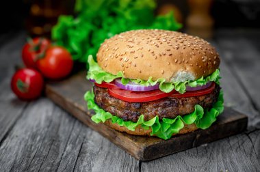 Tahta masada taze lezzetli bir burger. Restoranda nefis ızgara yemekler.