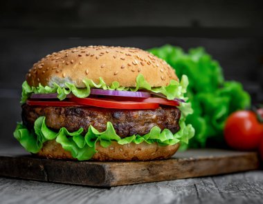 Tahta masada taze lezzetli bir burger. Restoranda nefis ızgara yemekler.