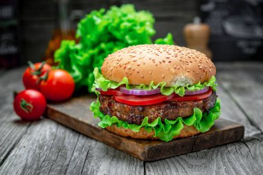 Tahta masada taze lezzetli bir burger. Restoranda nefis ızgara yemekler.