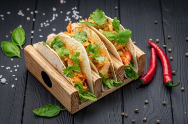 Mexican tacos with minced meat, beans, meat, vegetables and hot sauce. Photo for the restaurant menu