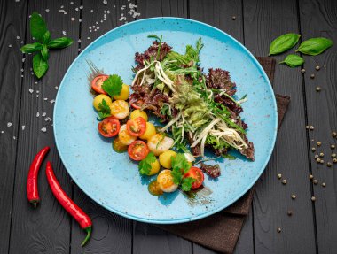 Grilled sea scallops with lettuce and tomatoes. Photo for the restaurant menu