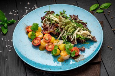 Grilled sea scallops with lettuce and tomatoes. Photo for the restaurant menu