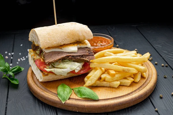 Smoked beef panini sandwich, served with salad and french fries. Photo for the restaurant menu