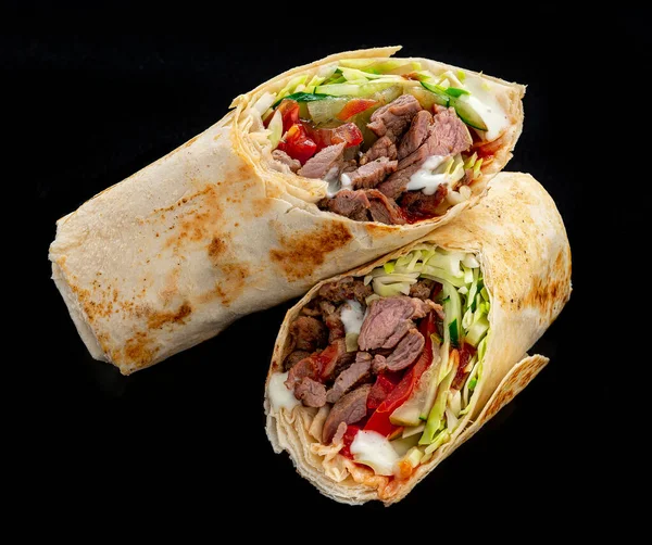 Beef shawarma on a dark background. Shawarma with beef in pita bread. Photo for the menu