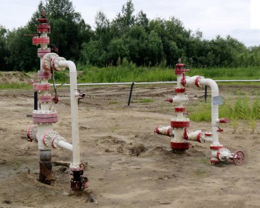 Bir kuyu kuyusu bölgesinde kuyu başı ekipmanlarıyla petrol kuyuları