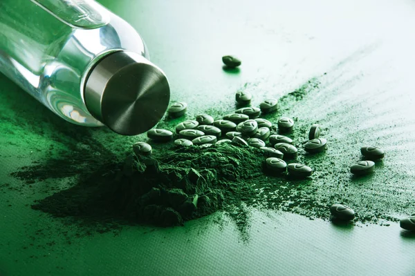 Yeşil arka plana saçılmış spirulina tabletleri. Yüksek kalite fotoğraf