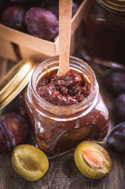 Cam kavanozda kaşıkla ev yapımı erik reçeli. 